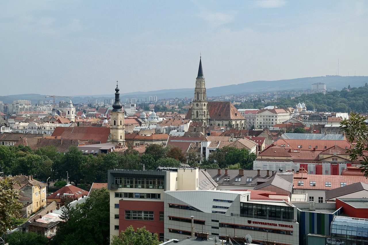 Панорама Клуж-Напоки: готическая башня церкви Святого Михаила, черепичные крыши и корпус Технического университета на переднем плане