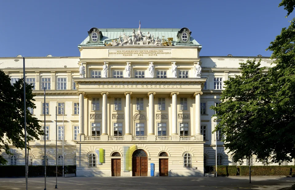 Classical façade with a colonnade, a rooftop sculpture group and the inscription Technische Hochschule