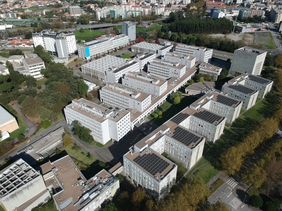 Aerial view of rows of white teaching blocks with solar panels among trees