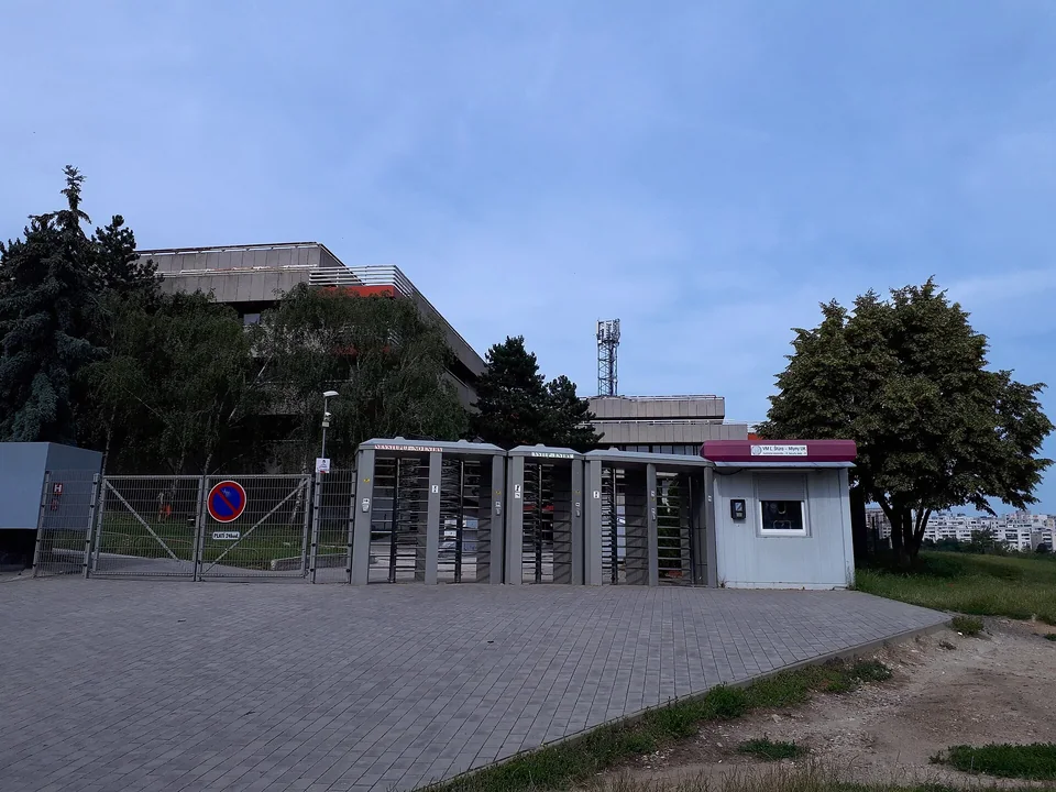 Турникеты и будка охраны у входа в общежитие Mlyny в Млынской долине Братиславы, за ними корпуса общежития