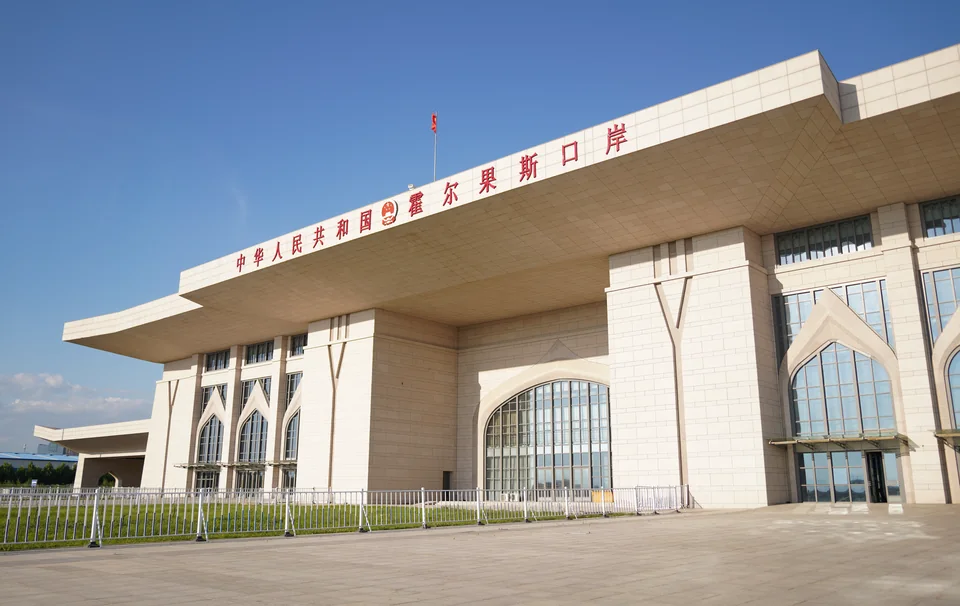 Pale border-crossing building with red Chinese lettering and arched windows