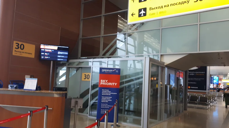 Airport departure area with the gate 30 desk, signs and a glass partition