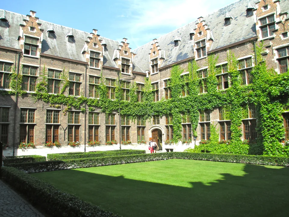 Brick courtyard with stepped gables, ivy-covered walls and a lawn in the middle