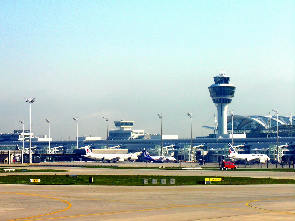Control tower, terminal and aircraft at the gates beyond the airfield