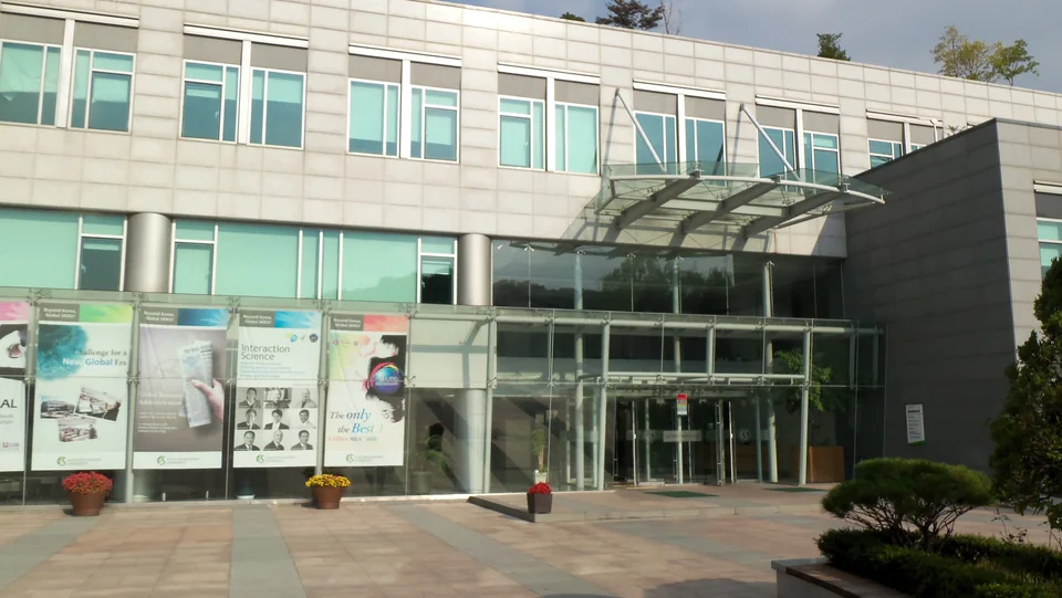 Вход в современный корпус International Hall со стеклянным фасадом и стендами у дверей