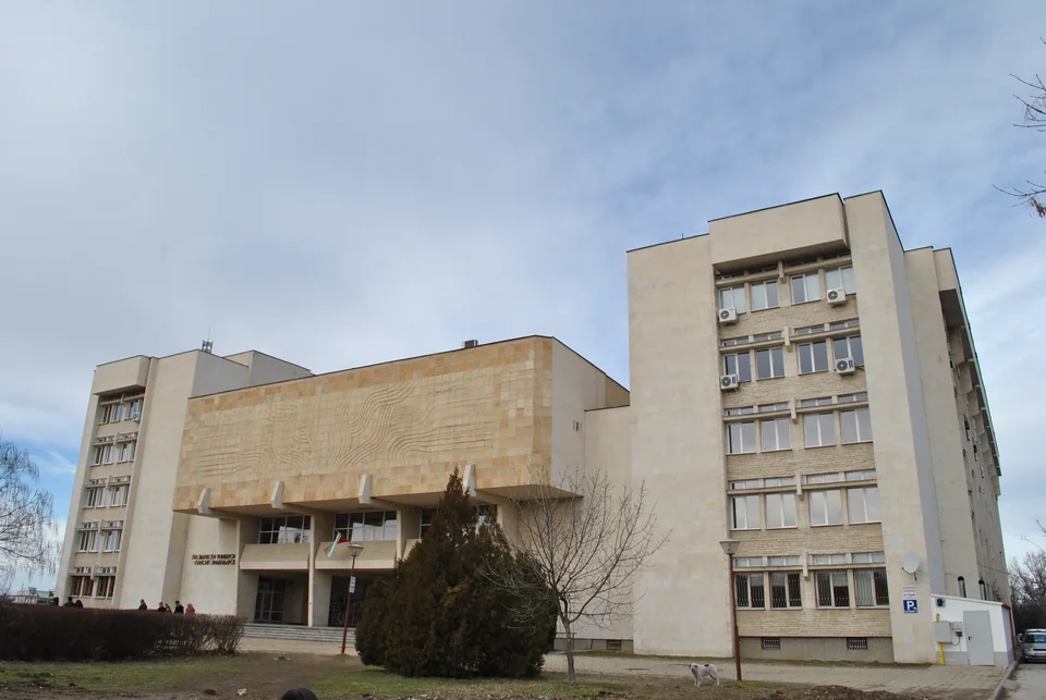 Корпус из светлого камня с рельефной стеной над входом и боковой башней